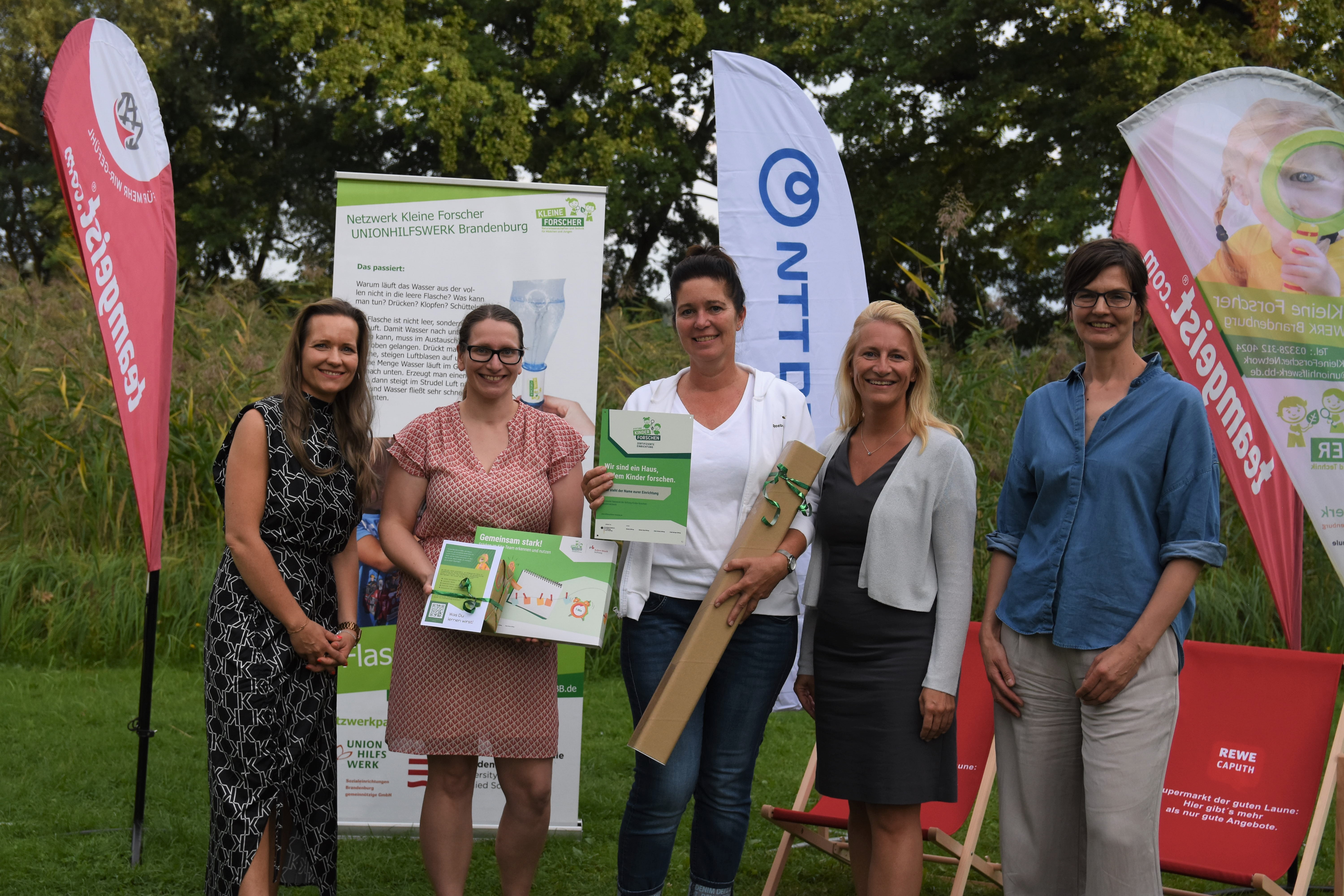 Vier Frauen stehen vor Aufstellern.