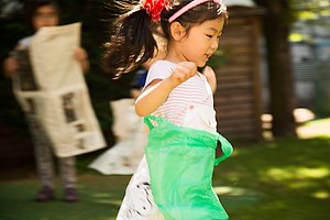 Ein Mädchen läuft mit einer Plastiktüte am Bauch