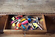 Alte Schreibtischschublade mit verschiedenen kleinen Dingen gefüllt
