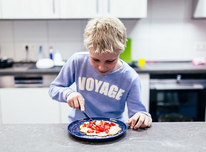 Junge schneidet einen runden Kuchen an