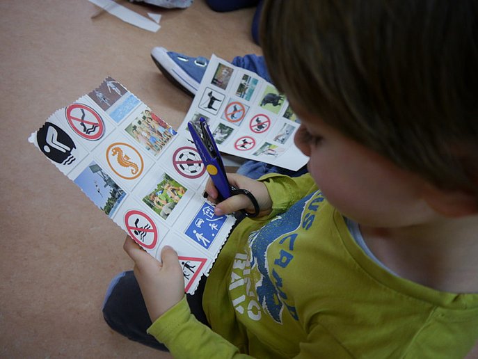 Ein Kind sieht sich verschiedene Piktogramme an.