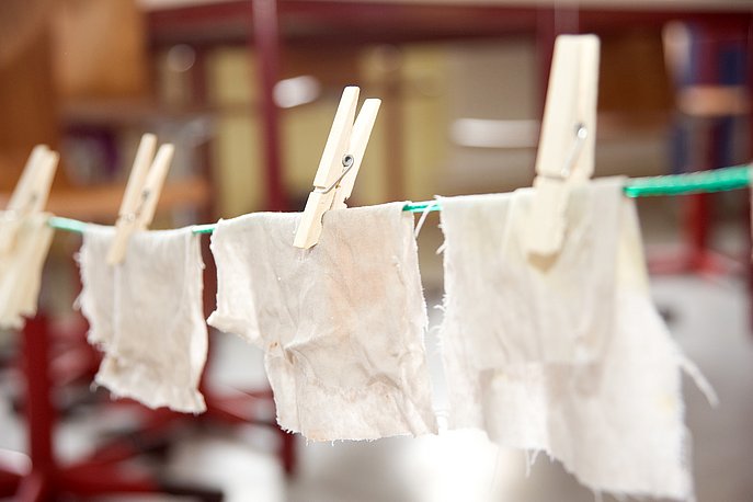 Nasse Stofftücher hängen an einer Wäscheleine