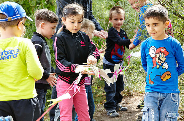Kinder hängen Zettel an Seile auf
