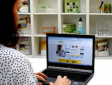 Frau mit Laptop surft auf der Website des Online-Campus
