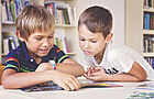 Zwei Grundschüler lesen geneinsam in einer Zeitschrift