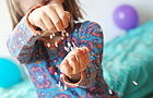Ein Kind spielt mit Konfetti in den Händen