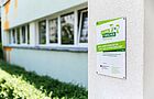 Plakette zur Zertifizierung als Haus der kleinen Forscher an der Außenwand einer Einrichtung.